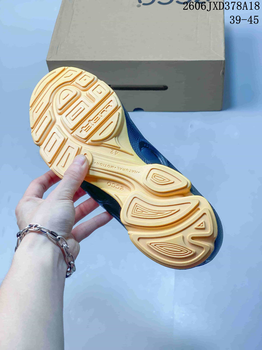 Close-up of the patterned orange outsole on a black ECCO BIOM sneaker.