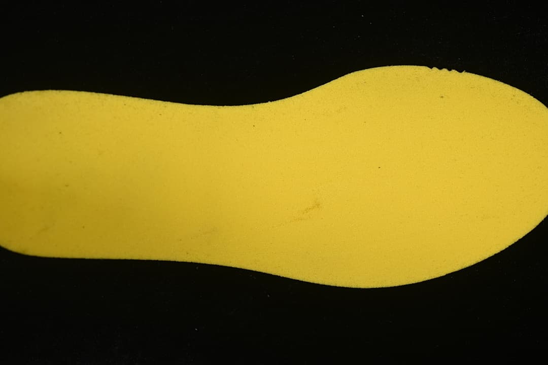 Yellow shoe insert shown against a dark background