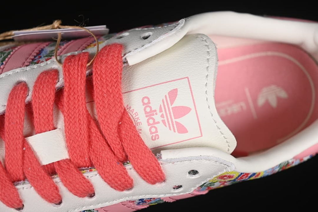 Close-up of coral laces, tongue branding and pink insole.