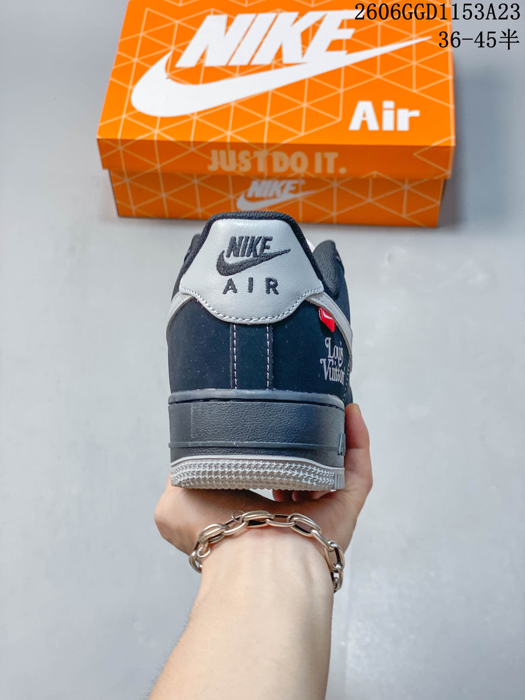Rear view showing a gray heel tab, dark navy upper, and decorative heel-side lettering