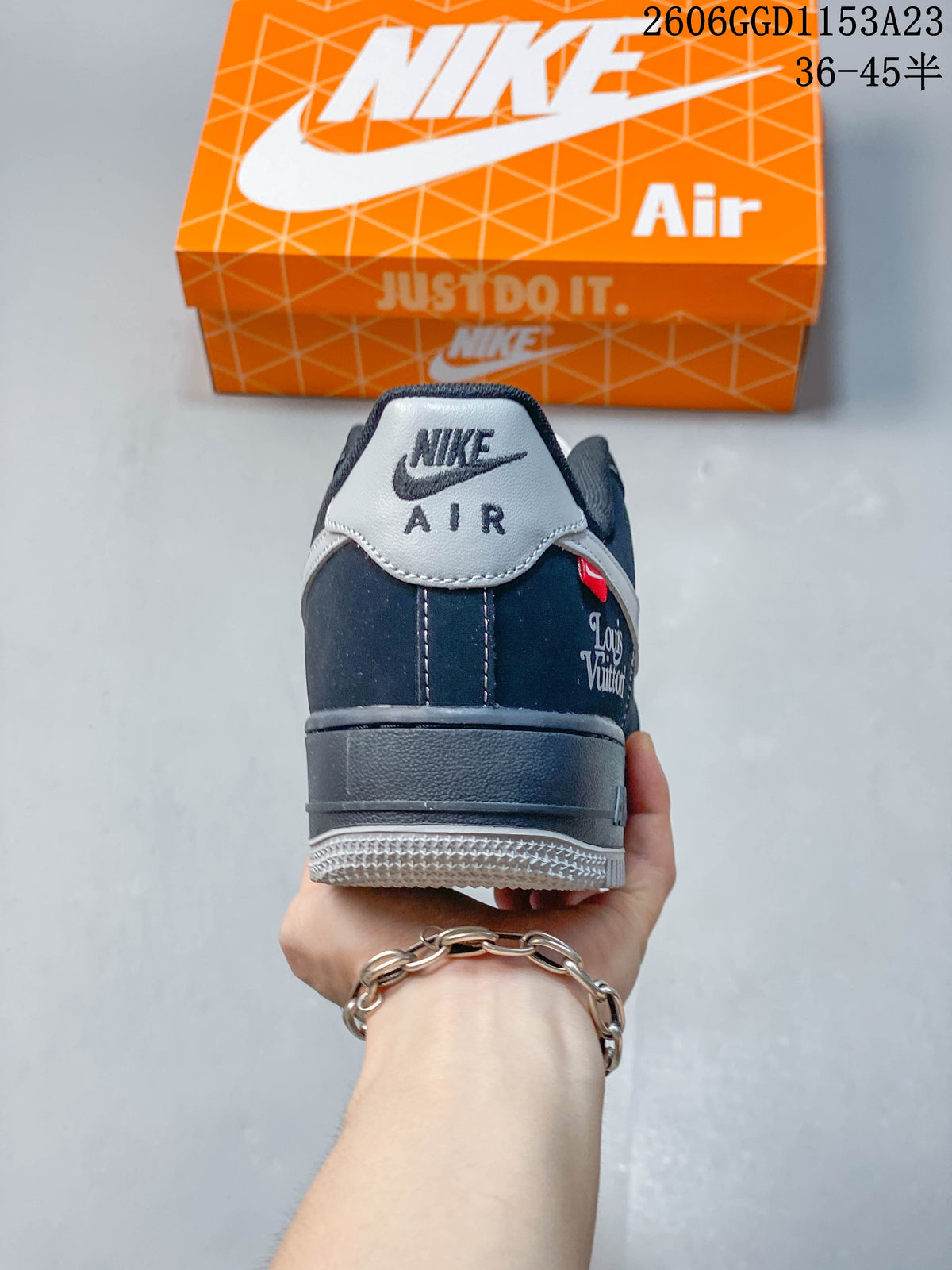Rear view showing a gray heel tab, dark navy upper, and decorative heel-side lettering