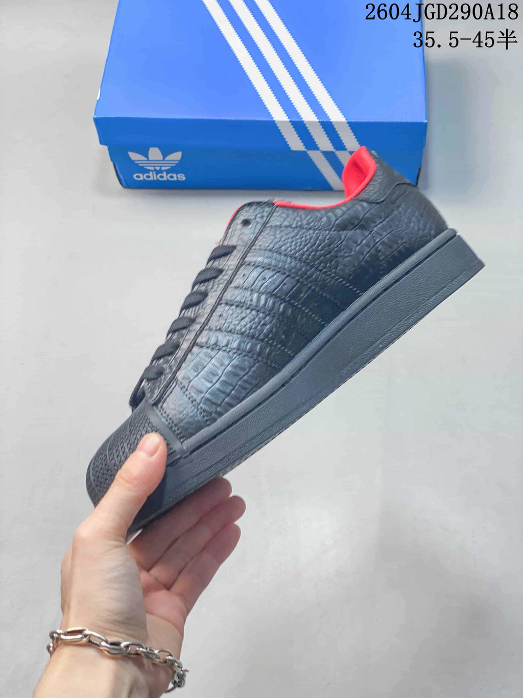 Side profile of a black Adidas Originals Superstar 2 sneaker with textured panels