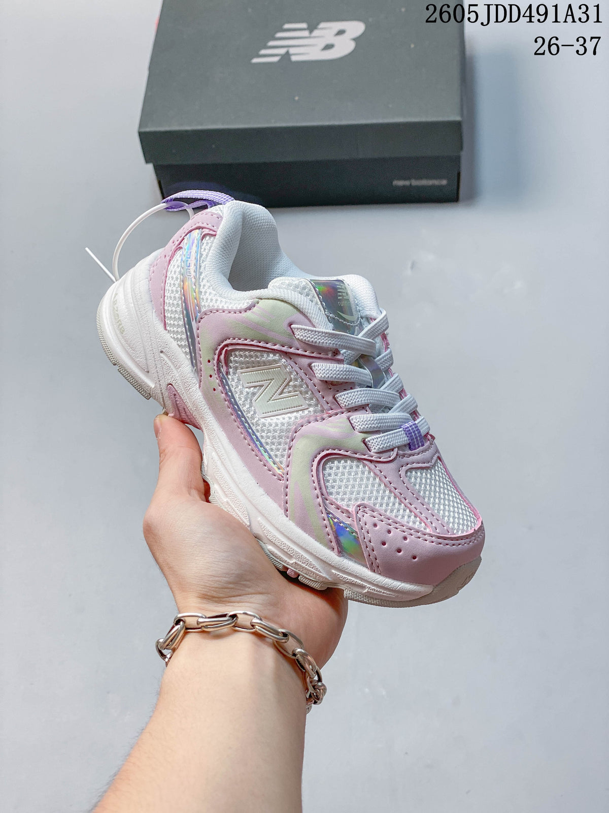 Pink and iridescent-accented kids' New Balance 530 lace-up sneaker shown in hand.