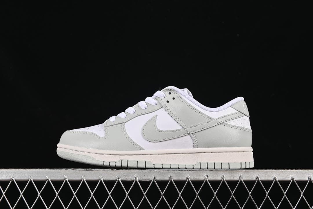 Side view of a white and light grey low-top Nike SB Dunk sneaker