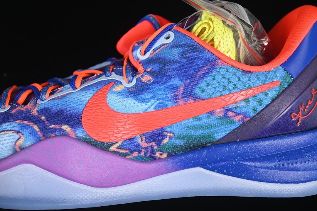 Close-up of blue patterned upper, orange Swoosh, and purple heel