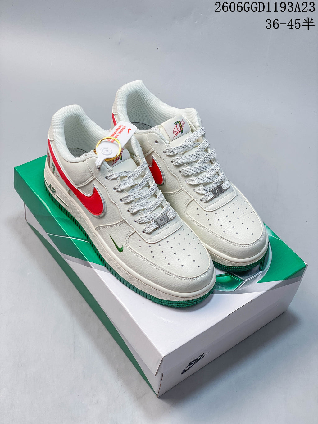 White low-top sneakers with red and green accents on a green-and-white box