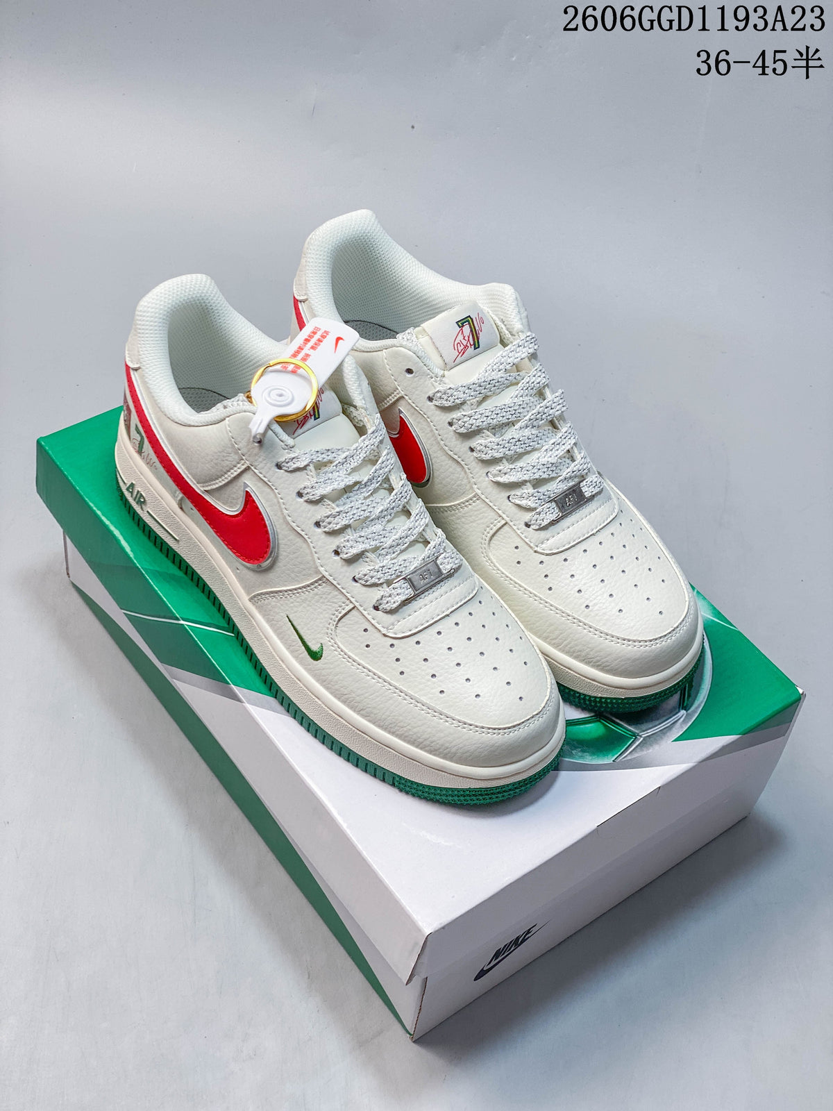 White low-top sneakers with red and green accents on a green-and-white box
