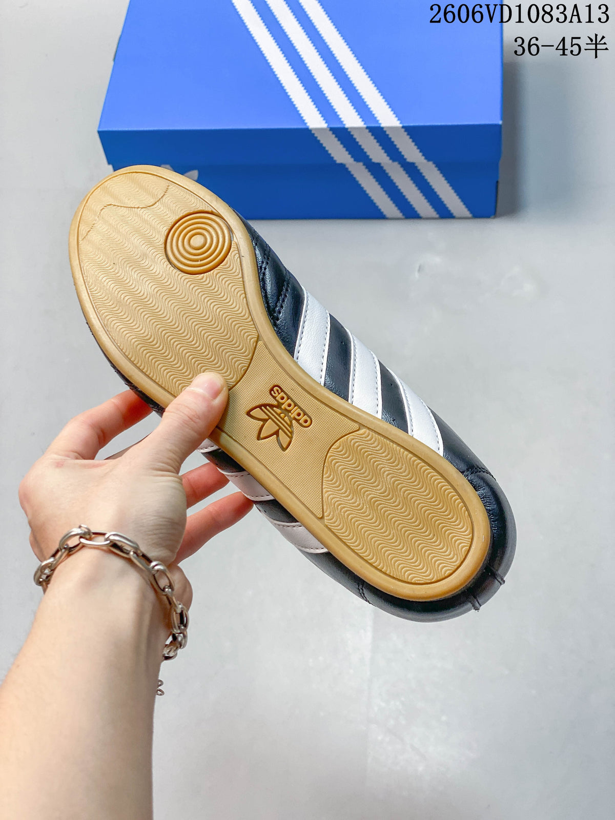 Underside of a navy Adidas Originals sneaker showing a gum-colored patterned outsole