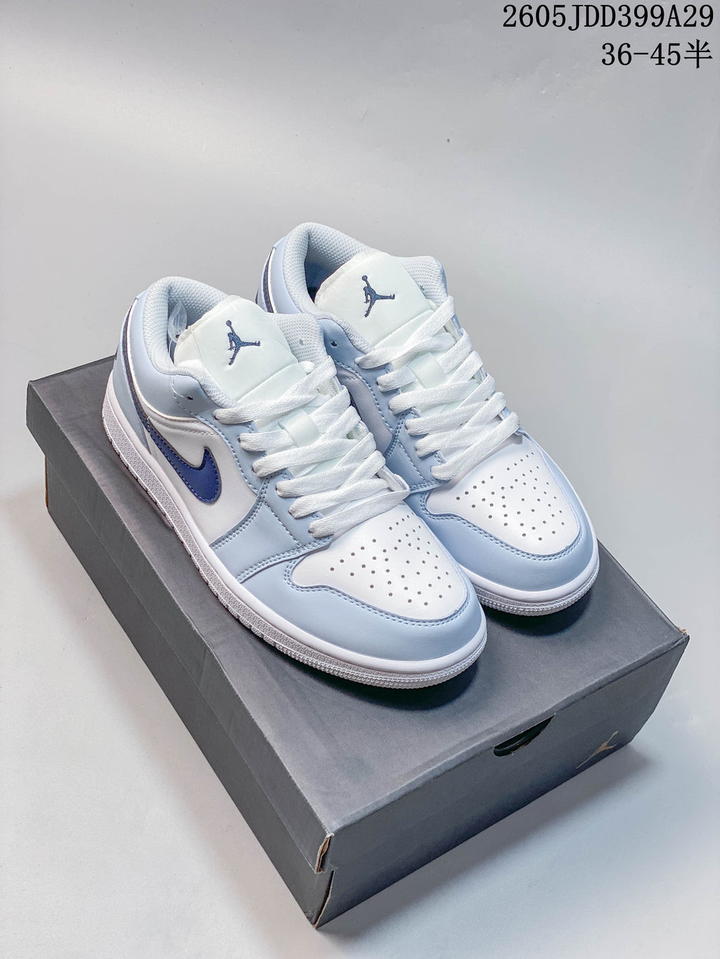 Pair of white and light blue Air Jordan 1 Low sneakers on a shoebox