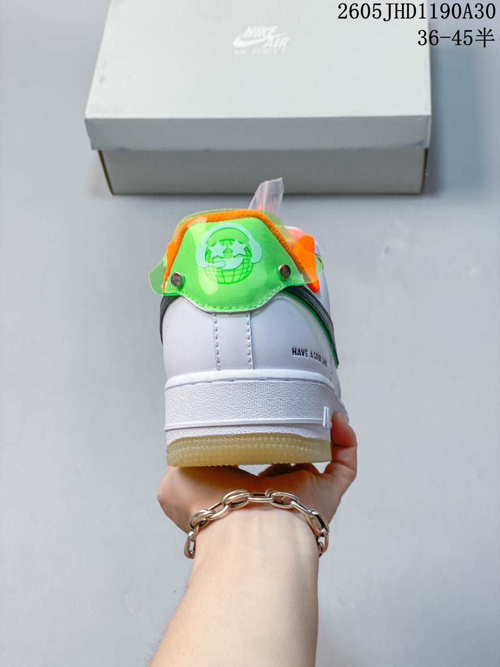 Rear view showing the sneaker’s green heel tab, orange lining, and white midsole