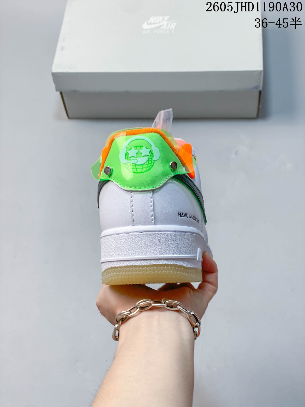 Rear view showing the sneaker’s green heel tab, orange lining, and white midsole