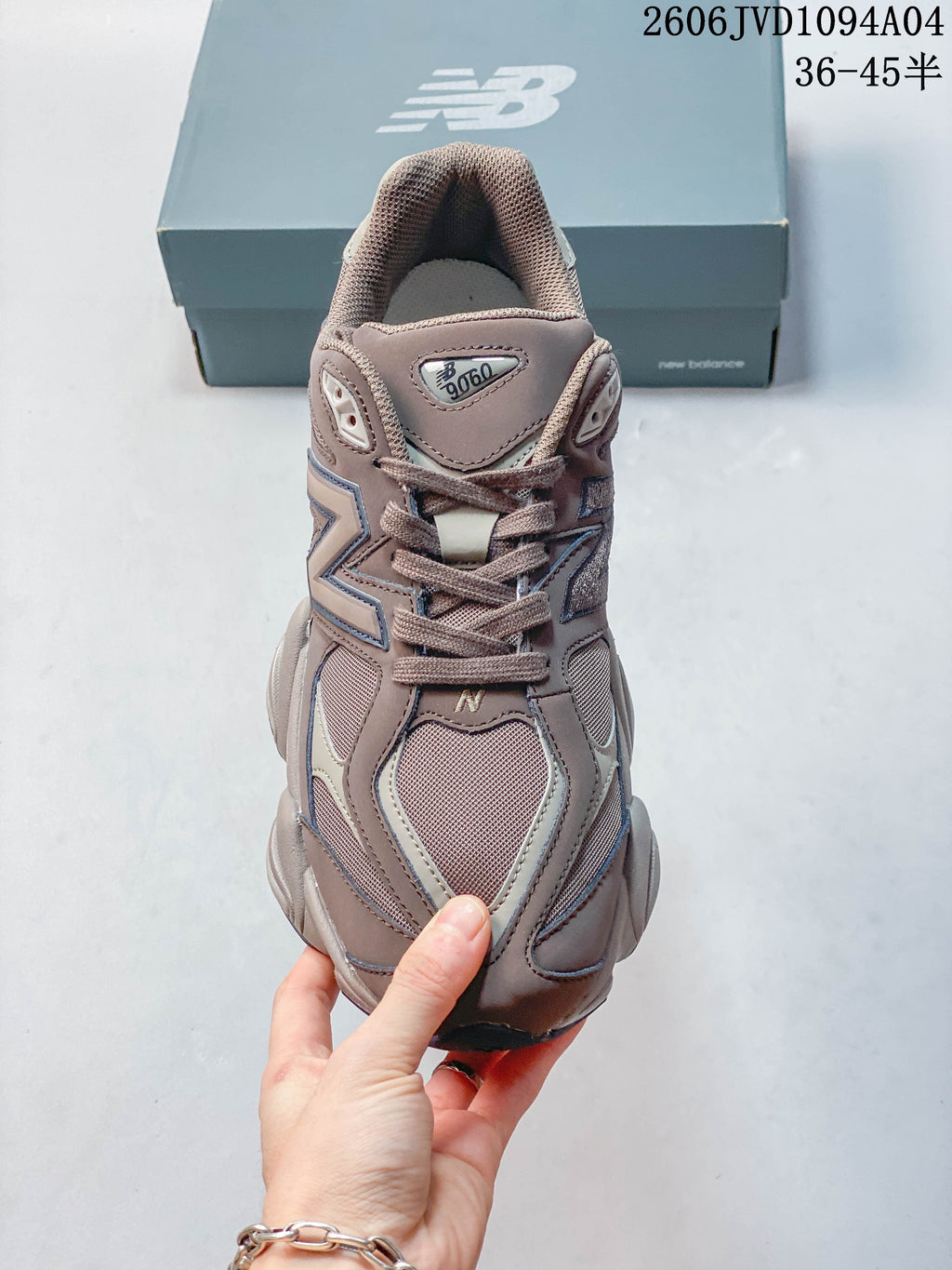 Front view of a taupe and gray lace-up sneaker