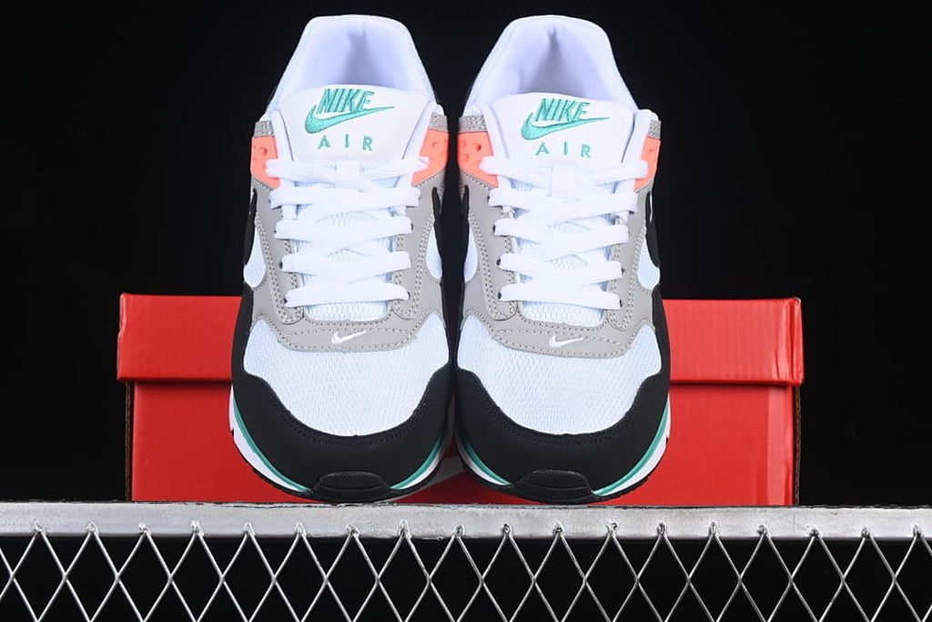 Front view of the pair showing the white toes, grey overlays, black accents, and teal details.