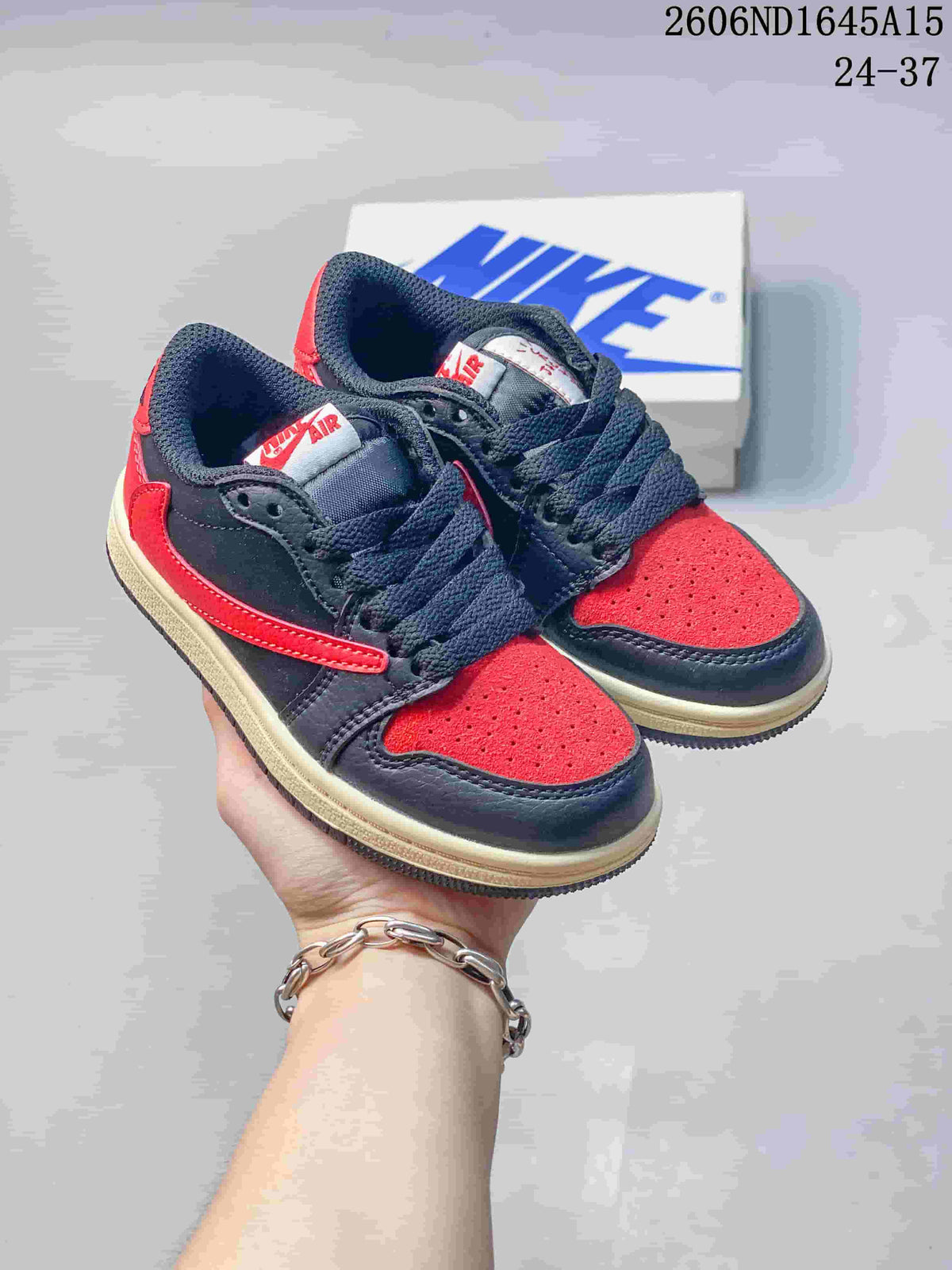 Pair of navy and red kids’ low-top sneakers with dark laces and cream midsoles.