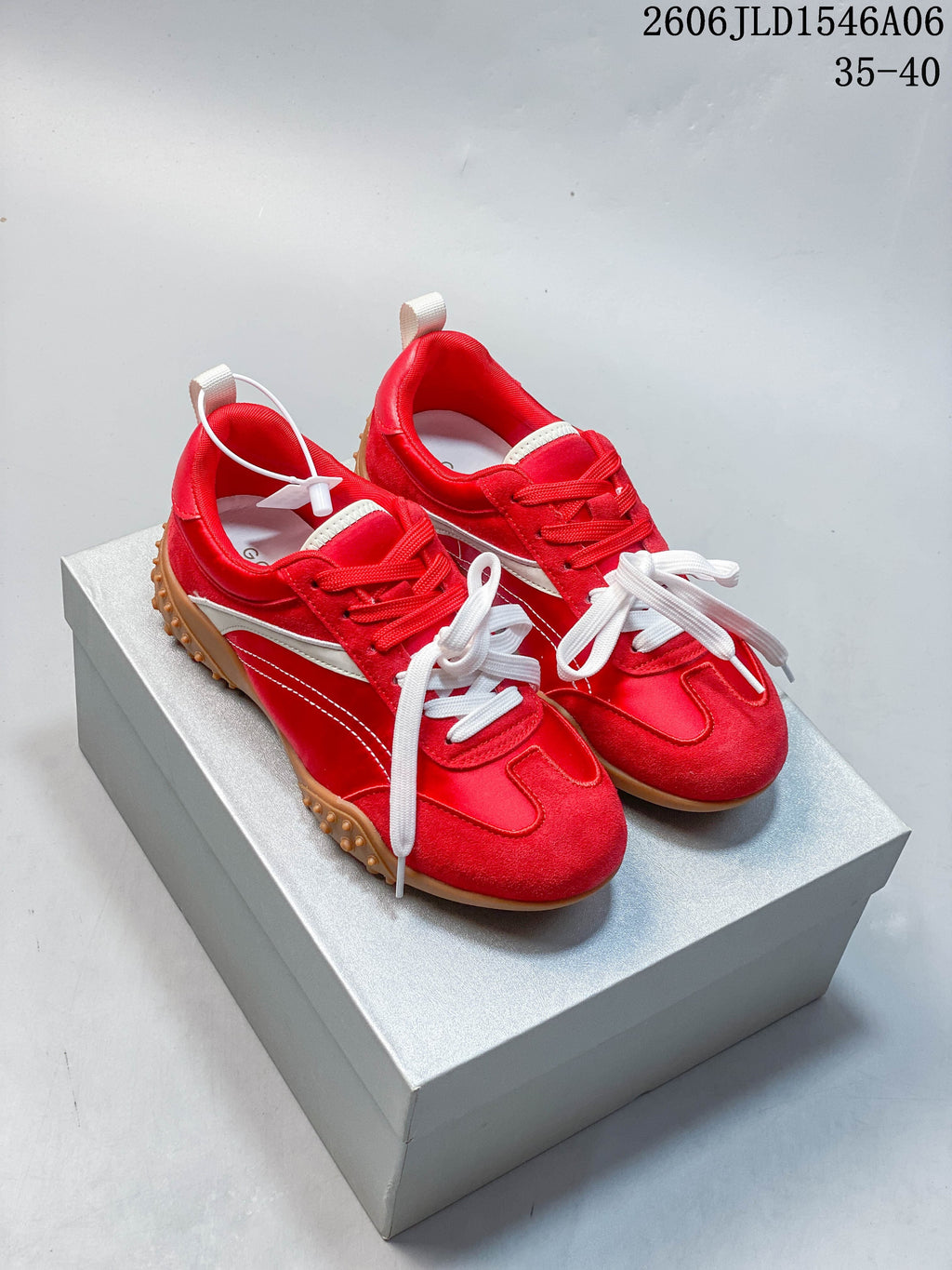 Pair of red and white low-top sneakers with gum-colored outsoles, shown from above.