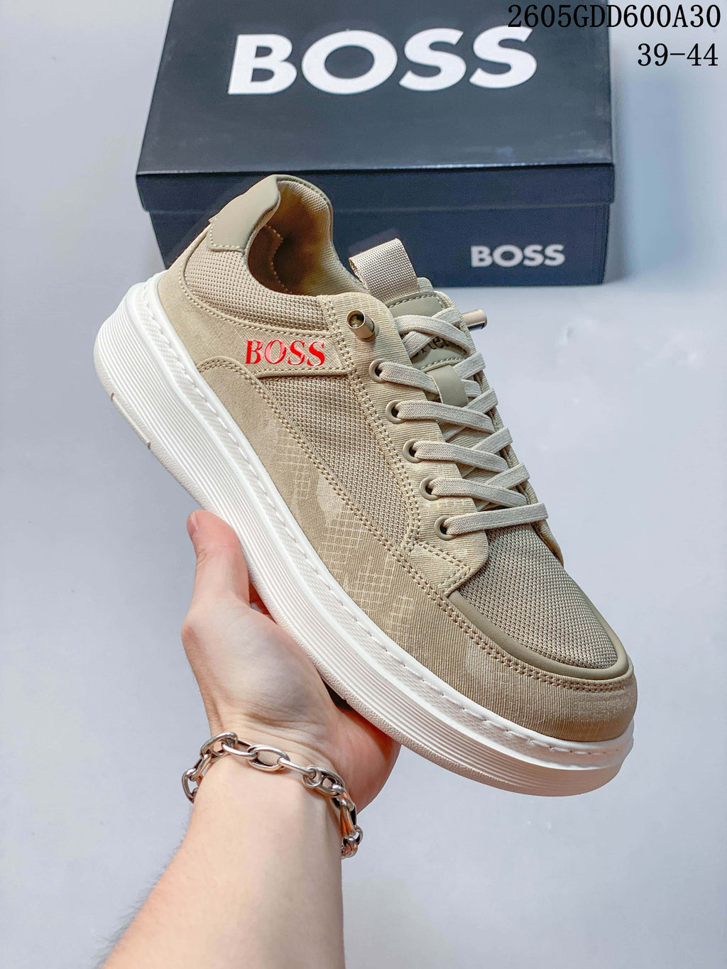 Angled side view showing the red BOSS logo on a beige sneaker