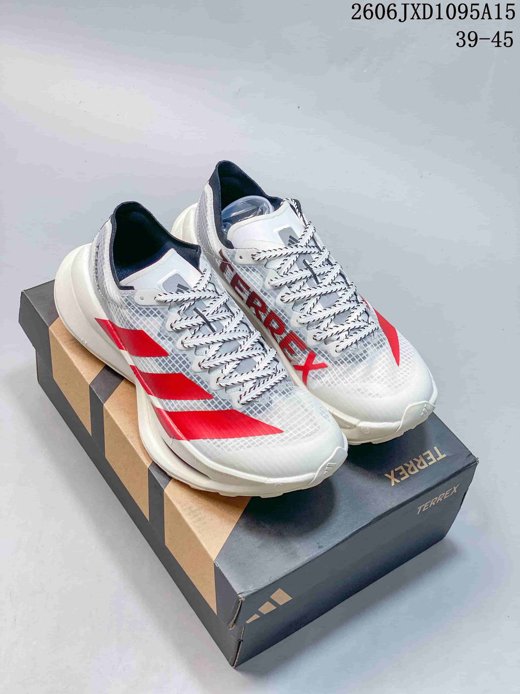 White Adidas Terrex shoes with red accents on a branded box