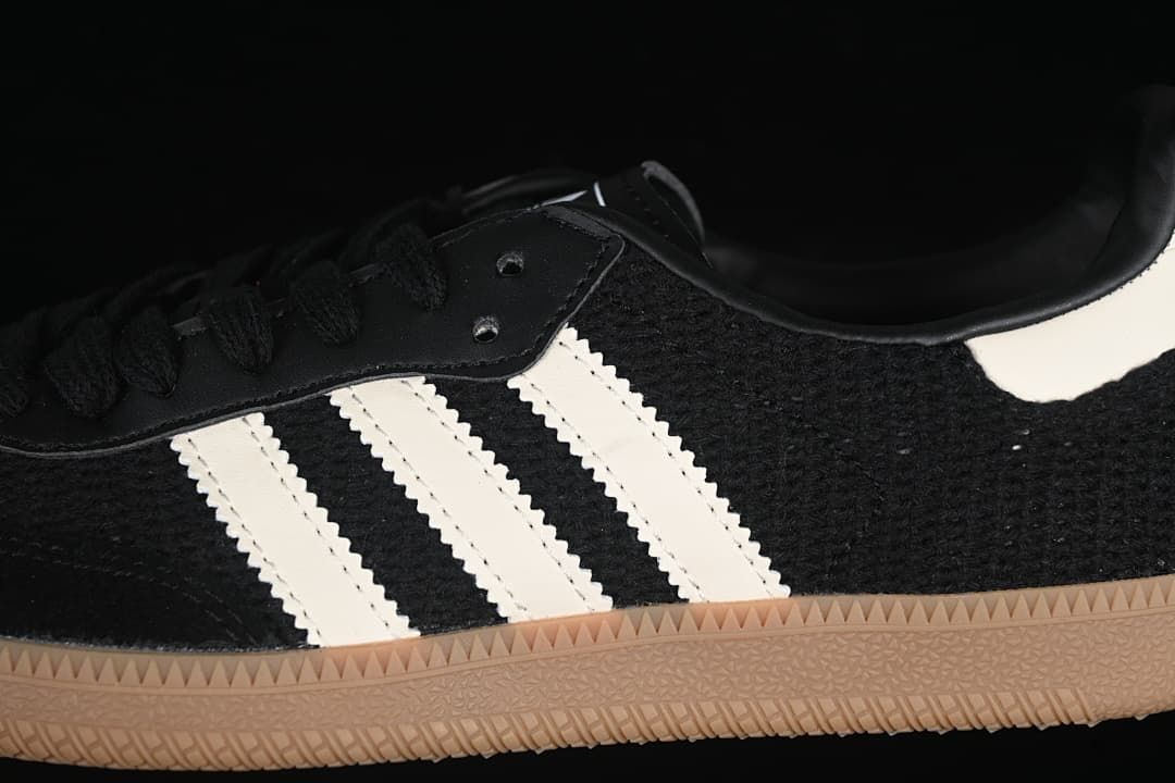 Close-up of the white side stripes, black upper, and gum-colored outsole