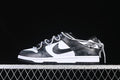 Side view of a black-and-white low-top sneaker with patterned laces and strap detail