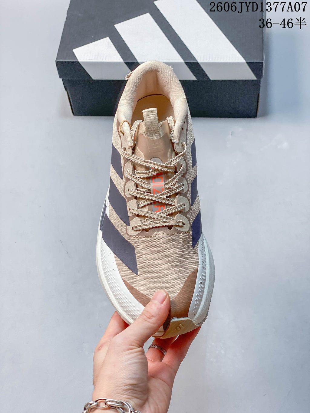 Top view of the beige Adidas Adizero Evo SL shoe with laces and navy side stripes.