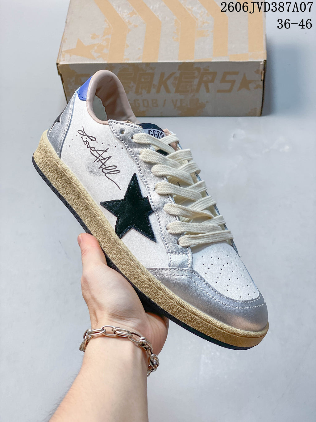 Close side view showing the dark star detail, white upper, silver panels, and cream-colored sole