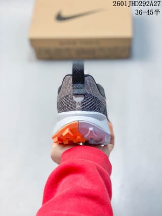 Rear view showing the heel pull tab, textured upper, white midsole, and orange outsole sections.