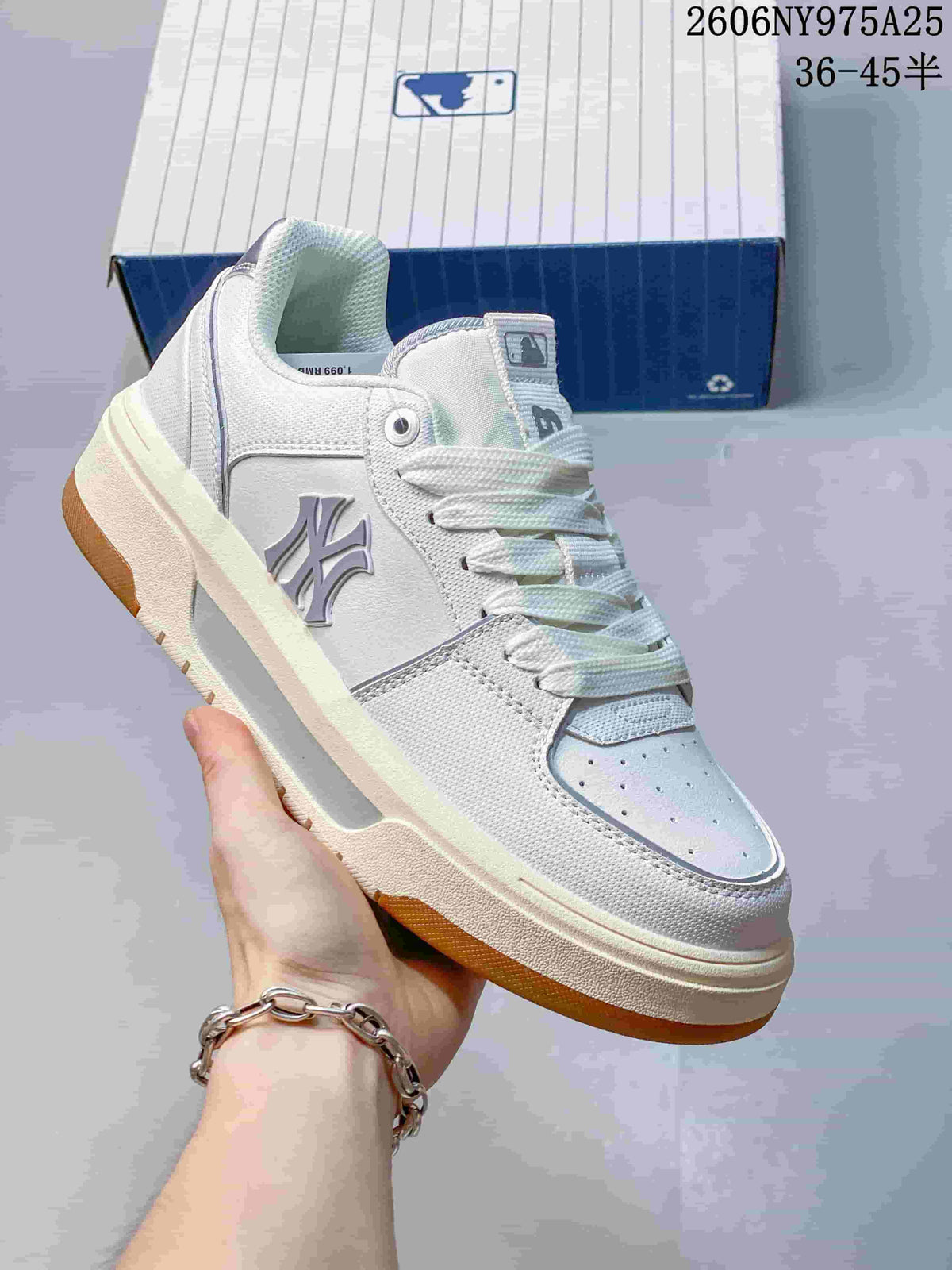 Angled side view showing the NY emblem, white upper, and gum-colored outsole.