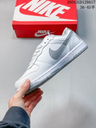 Side view of a white and grey Nike low-top sneaker showing the grey swoosh, layered upper and low-cut profile.