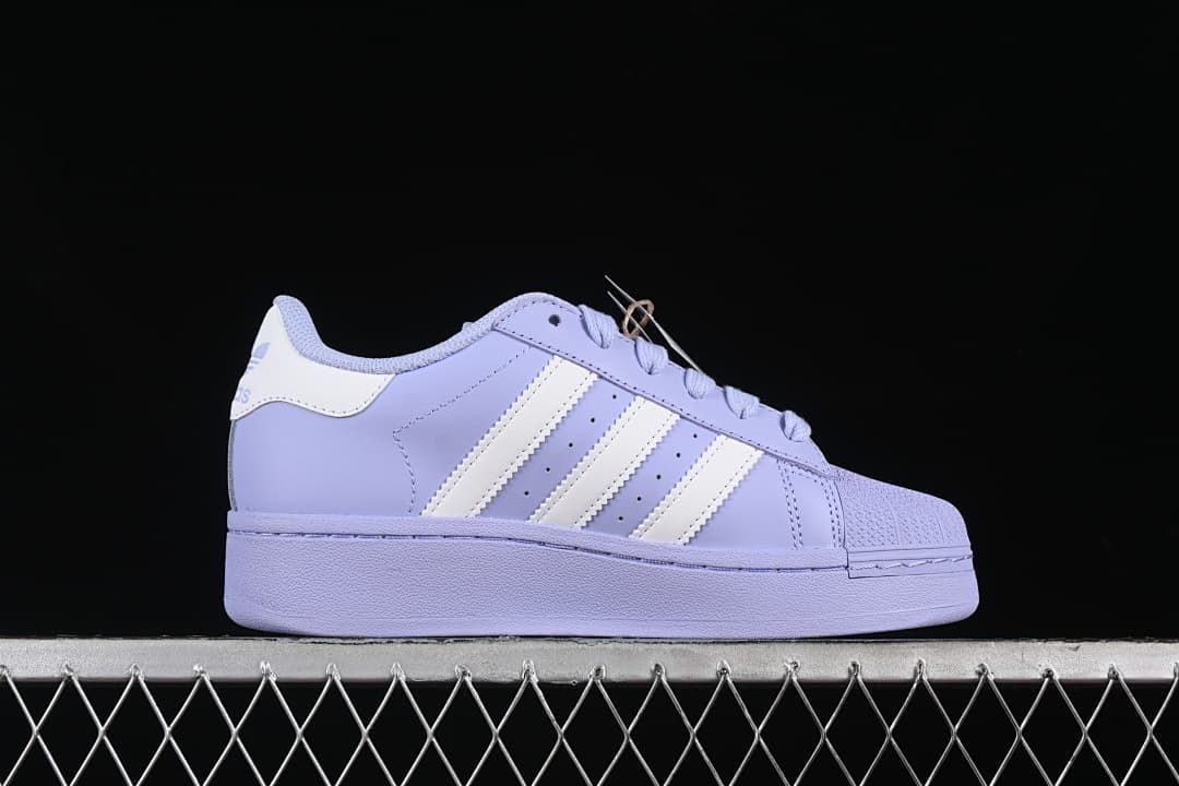Side profile of the lavender sneaker with white stripes and a chunky sole