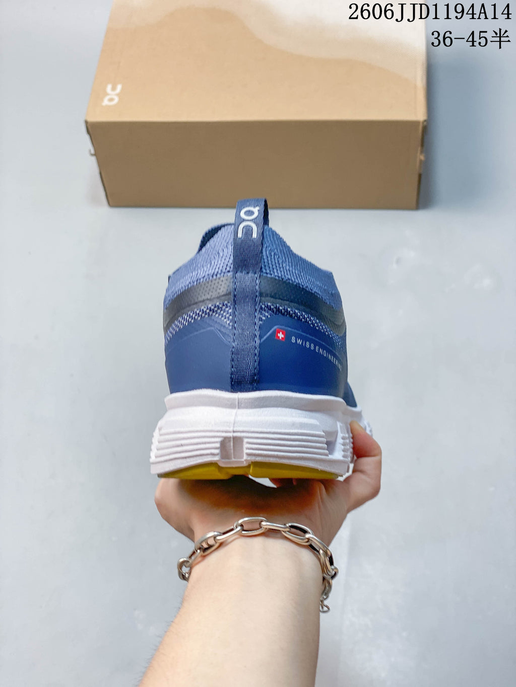 Rear view of a blue On Cloud 6 Versa sneaker with a heel pull tab and white outsole.