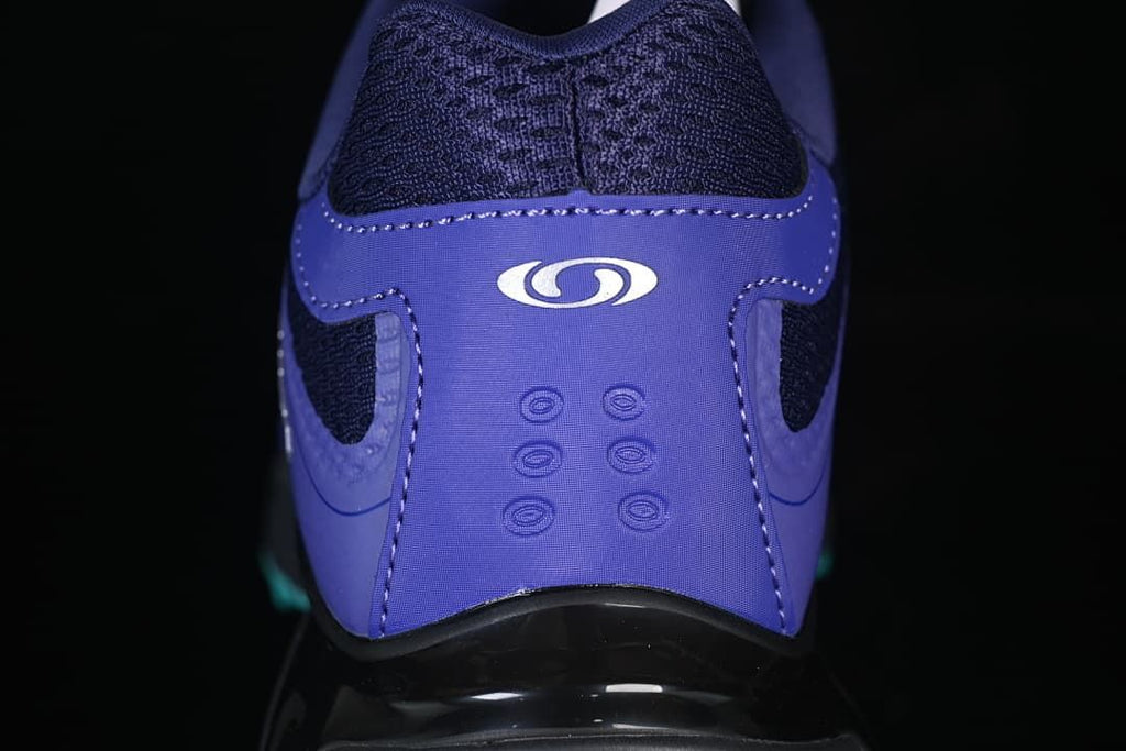 Rear view of the purple shoe heel with dark mesh and Salomon logo.