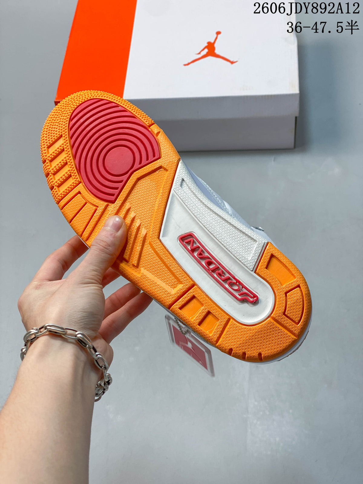 Bottom view showing the orange outsole and contrasting red traction area.