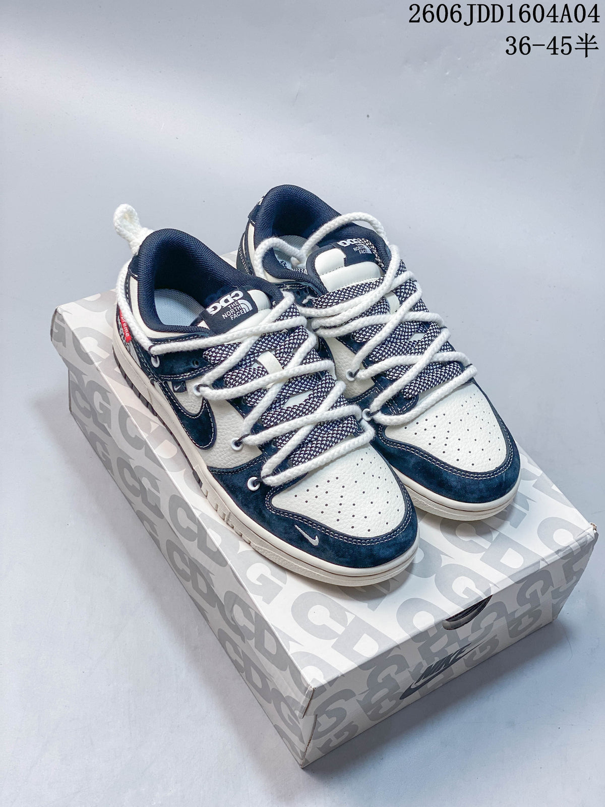 Pair of navy and off-white Nike SB Dunk Low-style sneakers on a patterned shoe box, shown from above.
