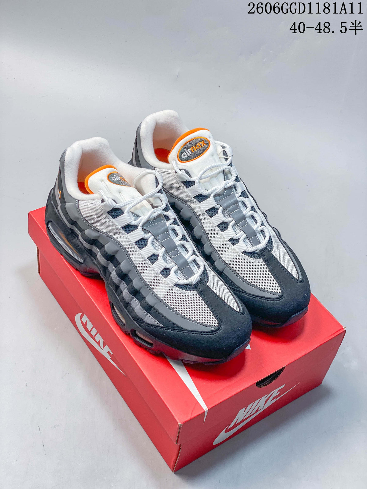 Nike Air Max 95 OG sneakers in gray, navy, white, and orange on a red shoe box