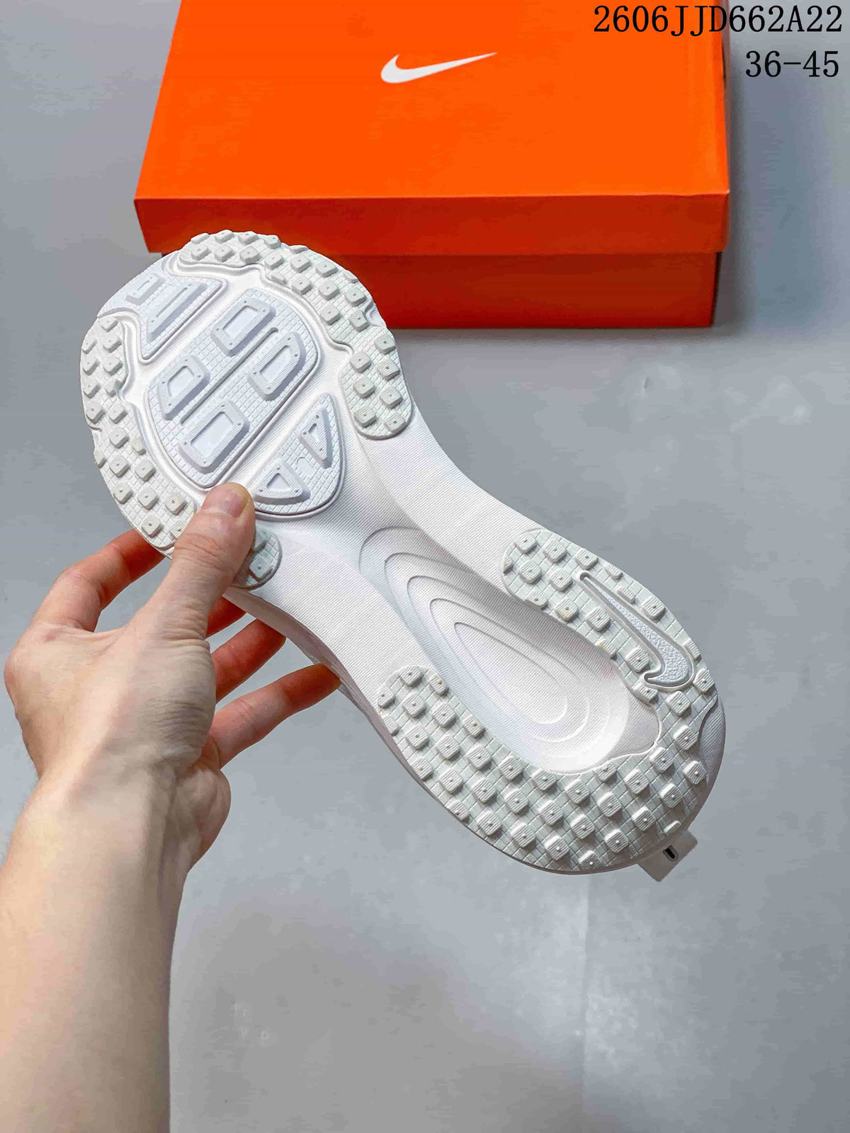 Underside view of a white running shoe showing its textured outsole