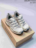 Pair of cream and gray Salomon XA Pro 3D trail sneakers on a branded shoebox