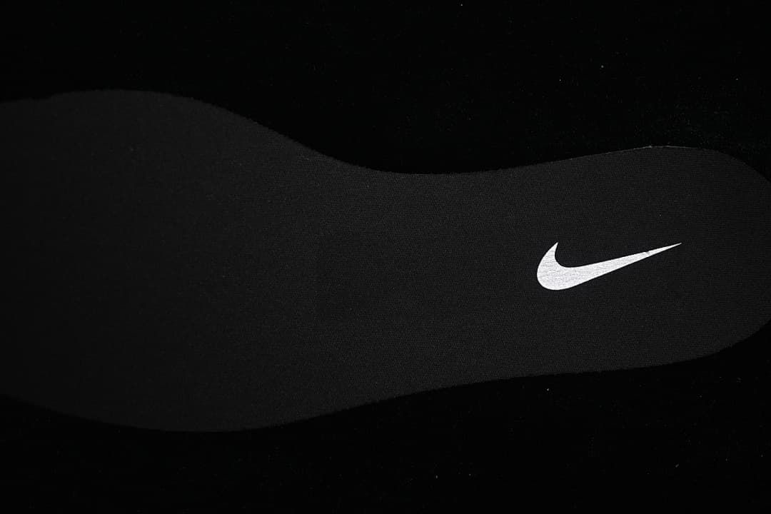 Black shoe insole with a white Swoosh mark.