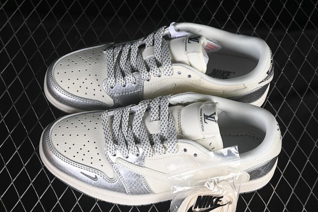 Pair of silver and white low-top sneakers shown from above with patterned laces and overlays.
