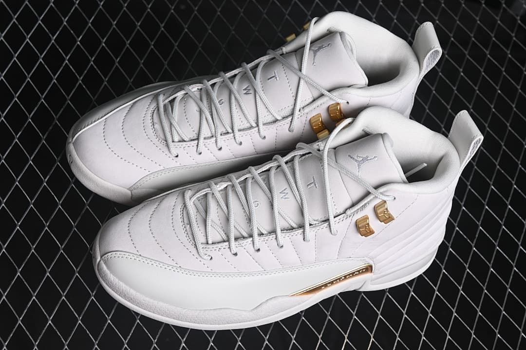 Pair of white Air Jordan 12 Retro sneakers with gold-tone details