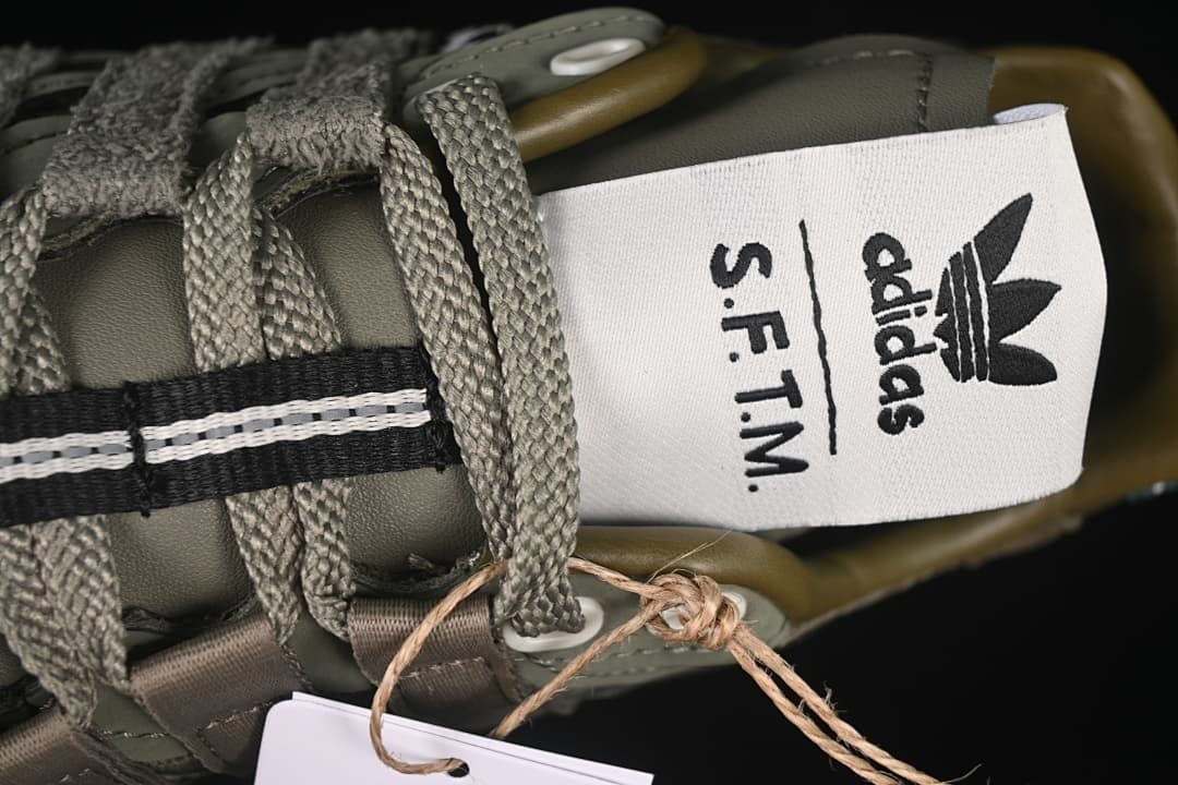 Close-up of the tongue label with adidas and S.F.T.M. branding.