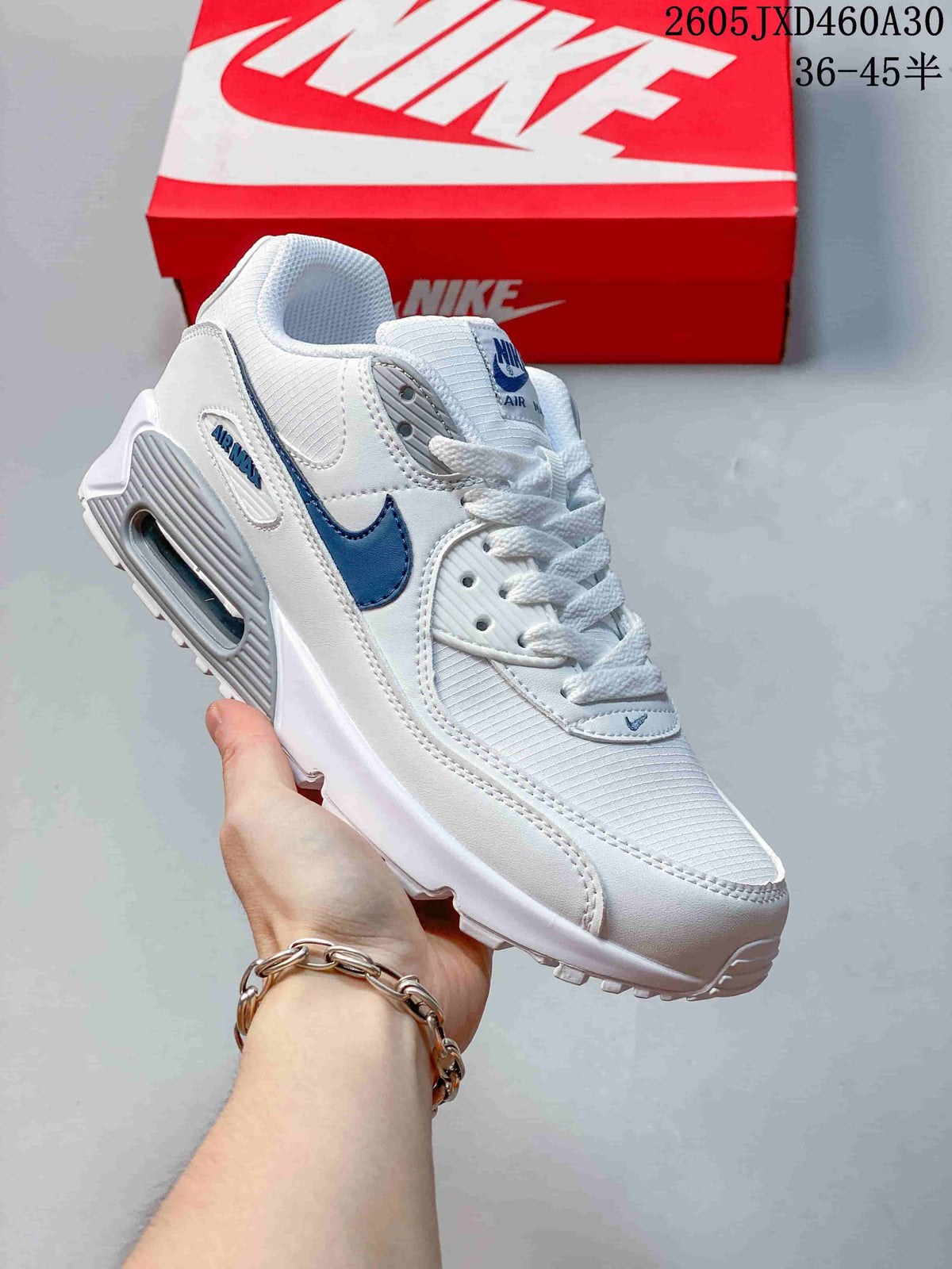 Angled side view of a white Nike Air Max 90 sneaker with blue accents