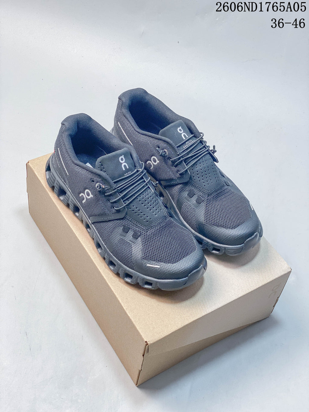 White and charcoal gray On Cloud 5 sneakers shown from the side, highlighting the segmented outsole.