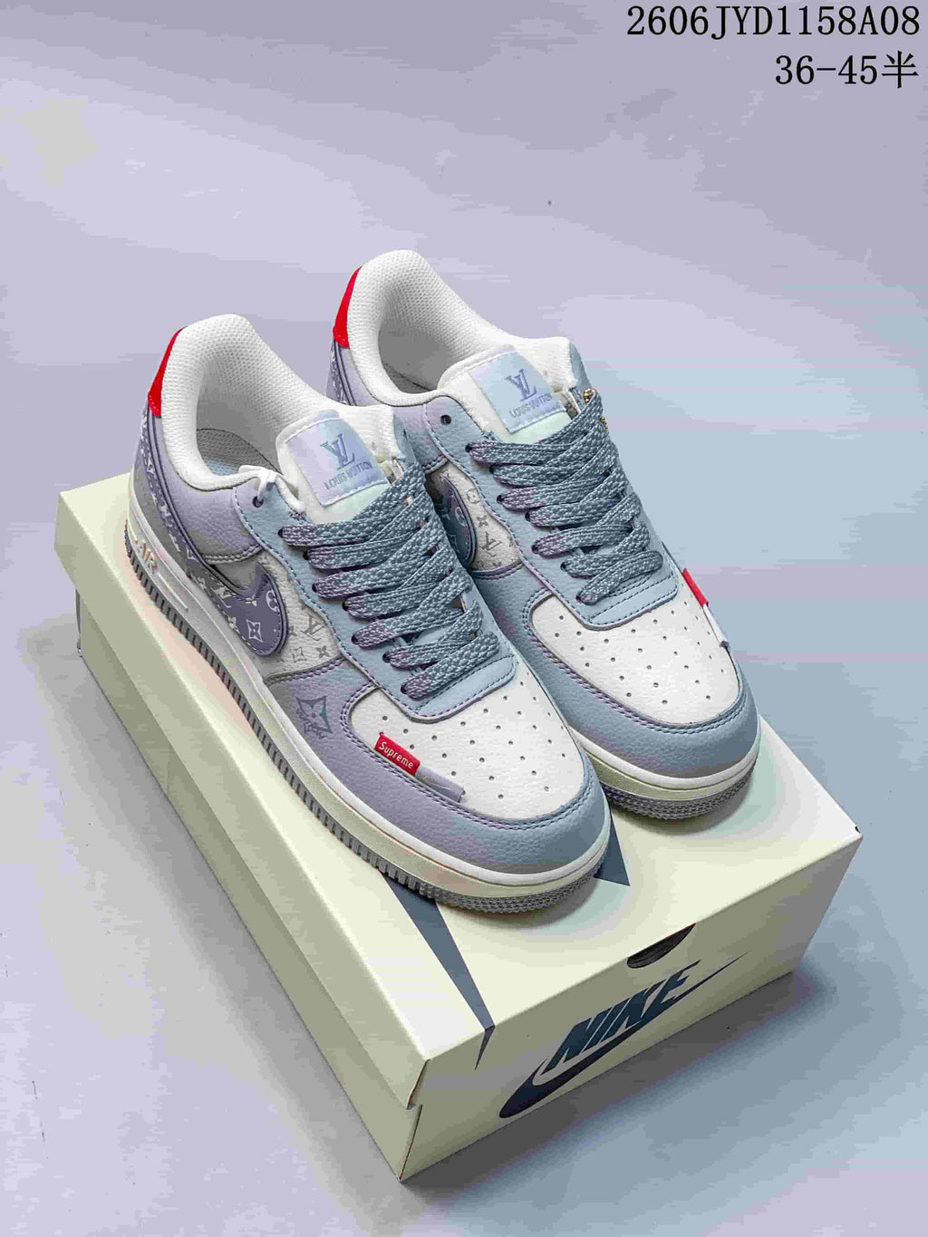 Pair of gray and white low-top sneakers with patterned panels, red accents, and a Nike shoe box