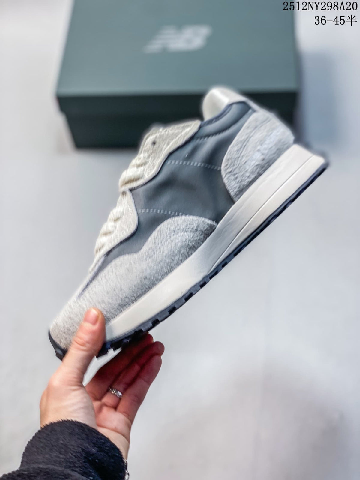 Side profile of a gray and navy New Balance 327-style sneaker