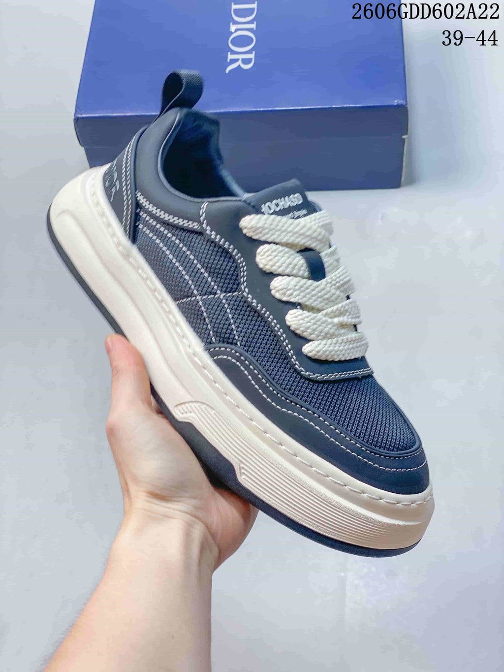 Close-up side view of a navy low-top sneaker with layered panels and a thick contrasting sole.