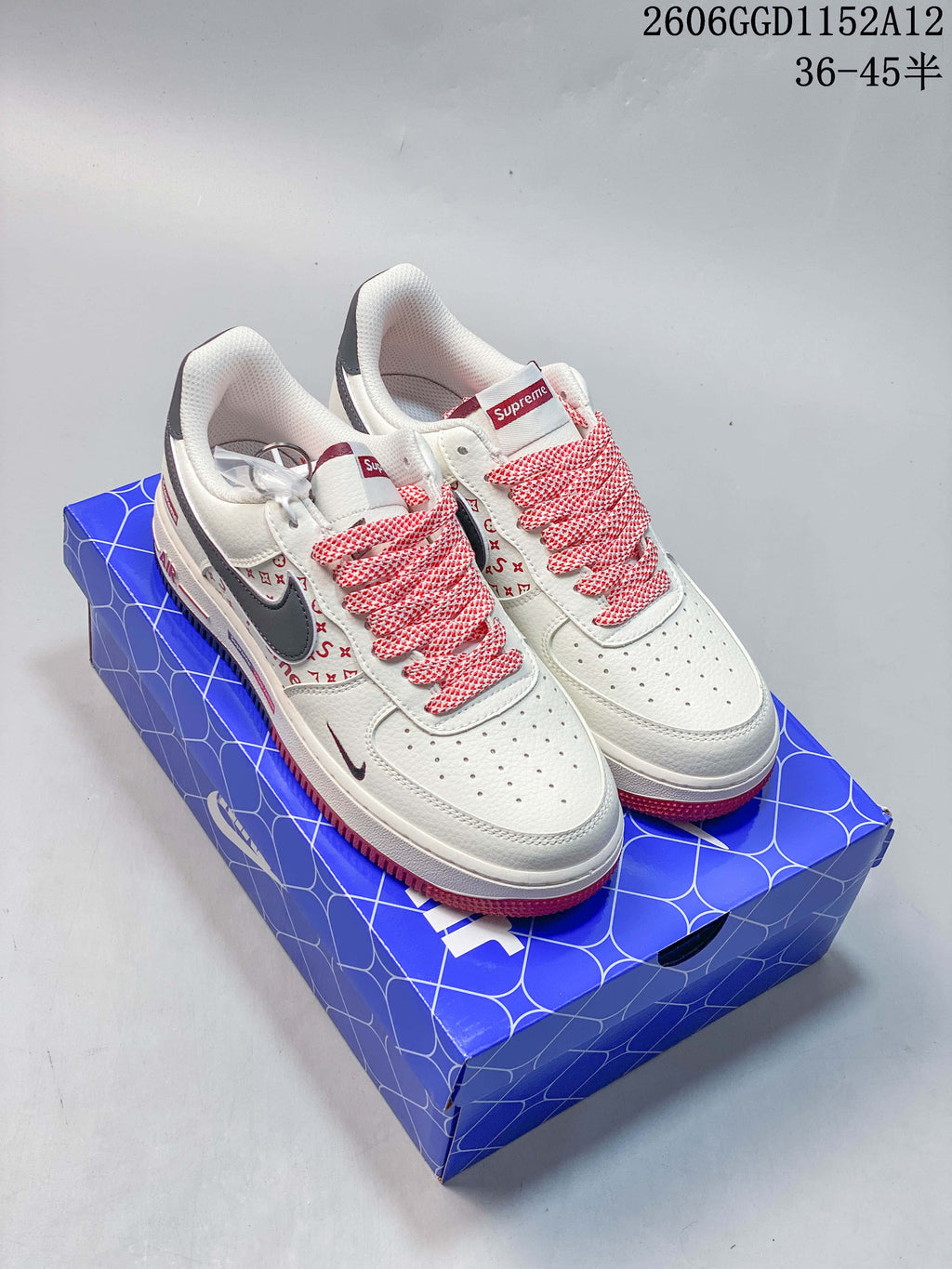 Pair of off-white low-top sneakers with gray swooshes, red patterned details and red-and-white laces
