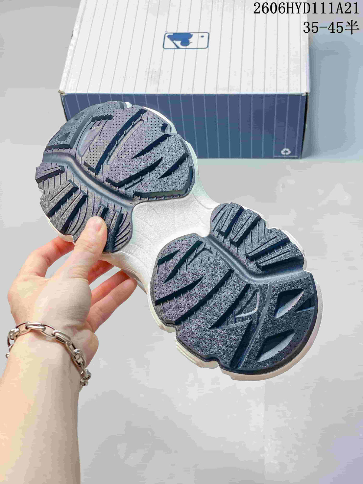 Close view of the sneakers’ dark segmented outsole and tread.