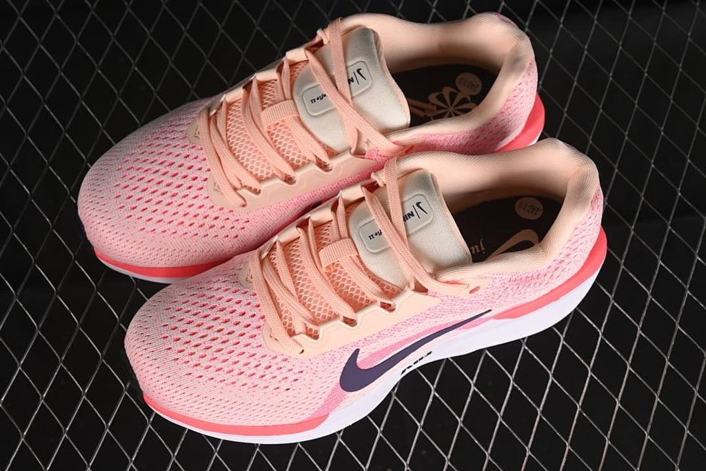 Pair of pink Nike Winflo 11 shoes shown from above at an angle.
