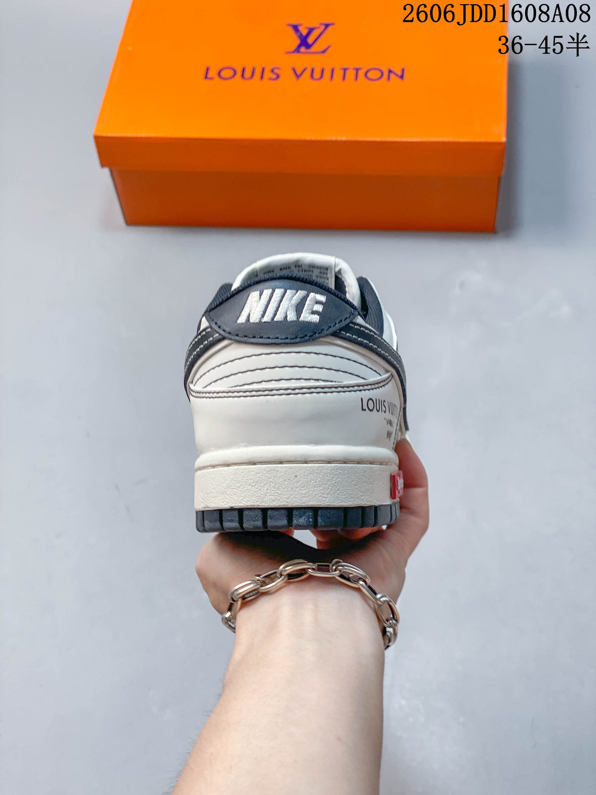 Rear view of a cream and gray low-top sneaker with dark heel accents