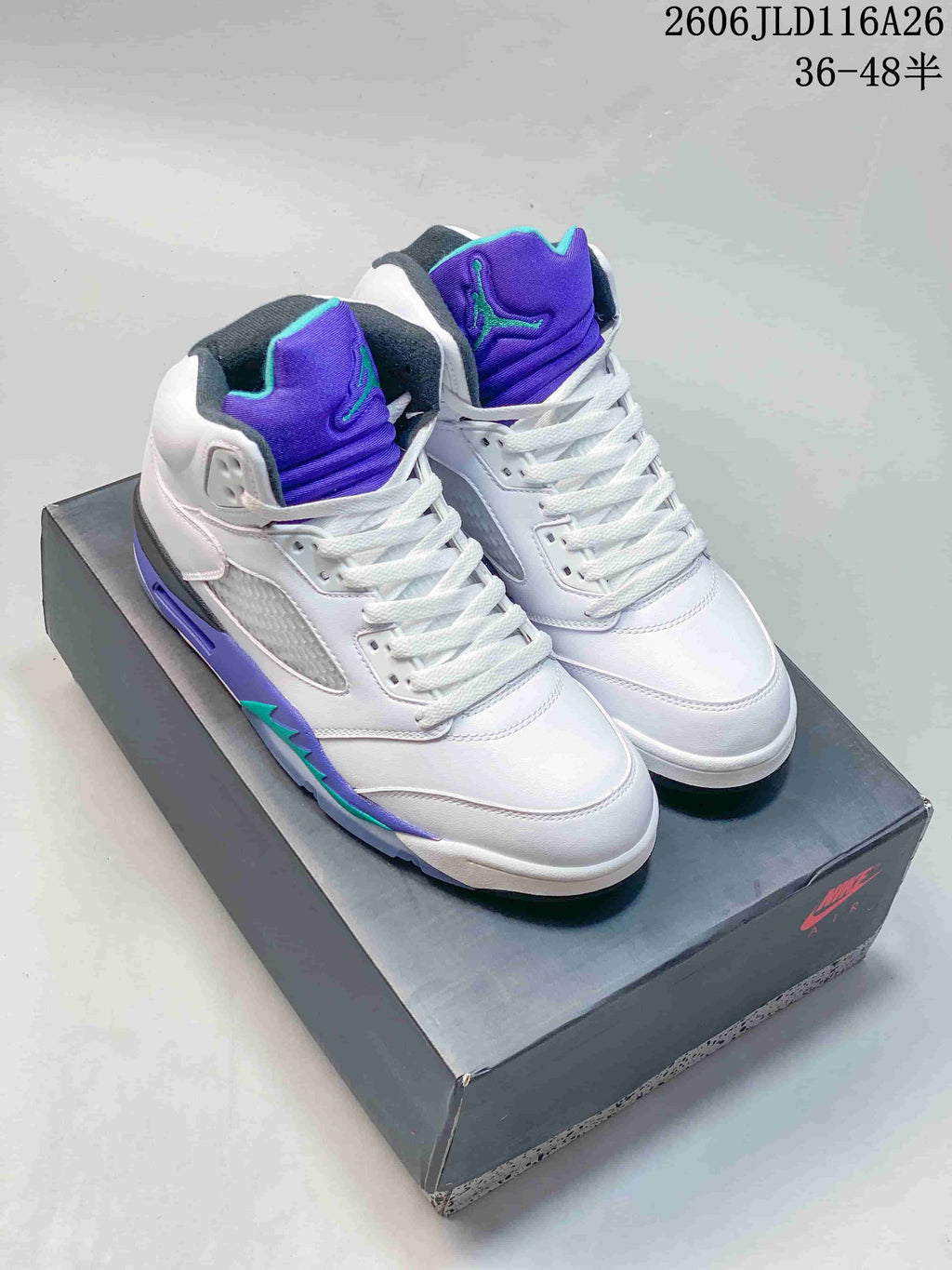 White high-top sneakers with purple and teal accents, shown on a shoebox